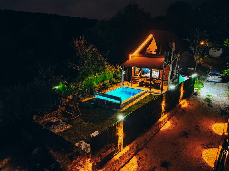 Gece, ışıklandırılmış havuz ve bungalov
